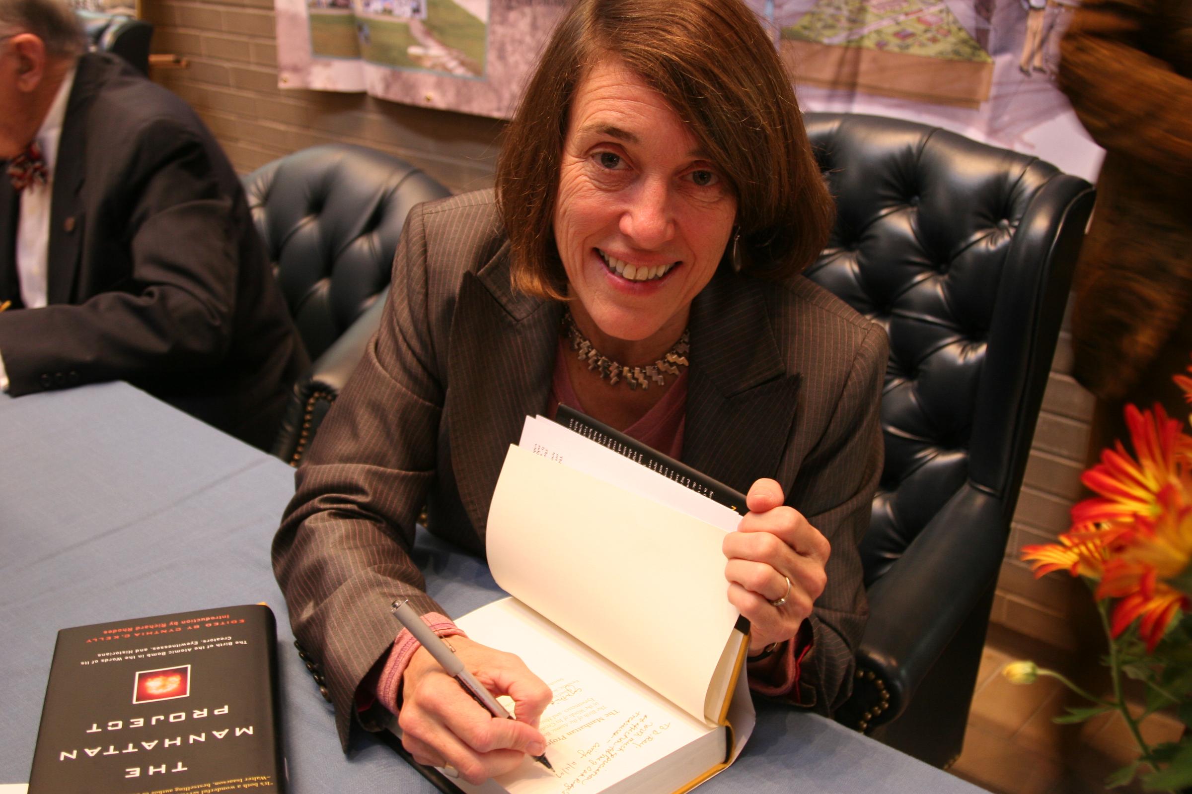 AHF President Cindy Kelly signing copies of The Manhattan Project anthology